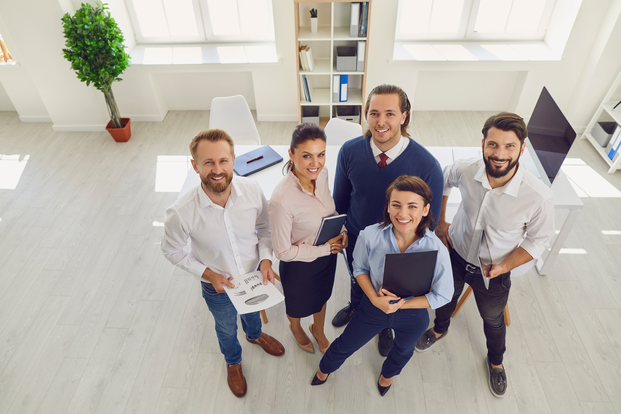 Satisfied Sales Department Employees Standing in Company Office Looking at Camera